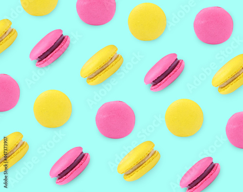 Delicious macarons on turquoise background, flat lay