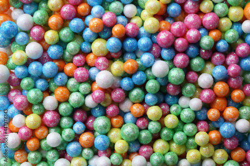 Pile of small colorful beads as background, top view