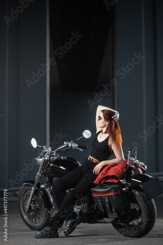 Girl biker sexually posing on motorcycle at night city