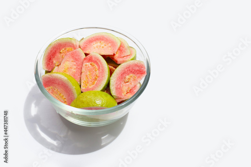 Fresh pink guava slices on glass bowl on white background.