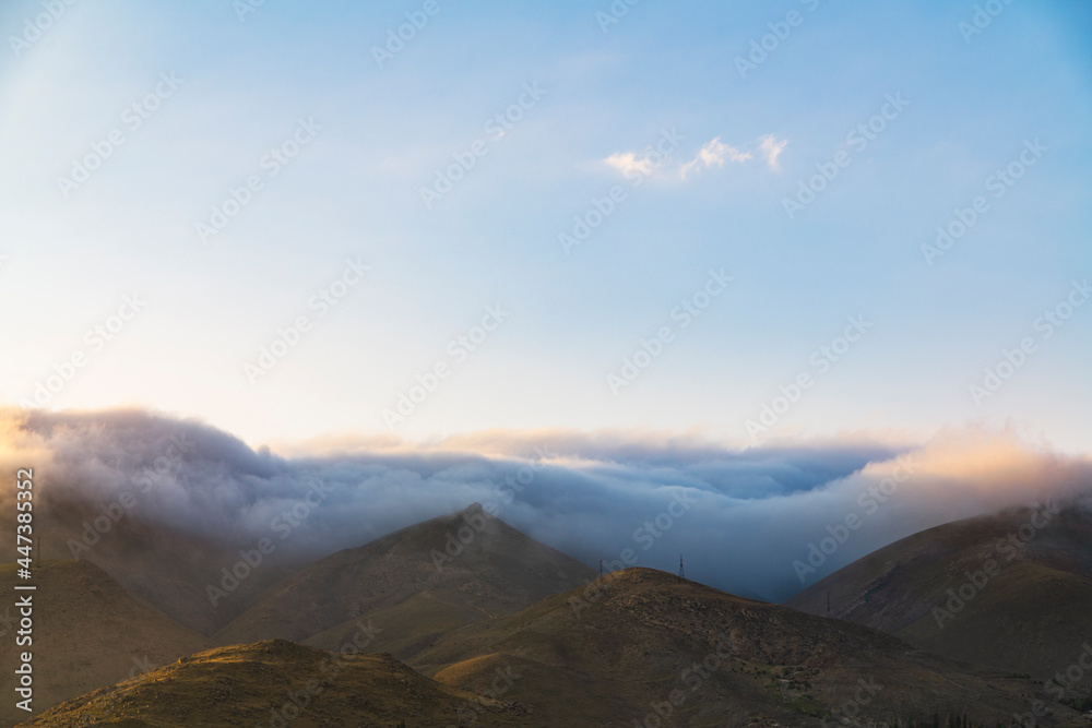 Beautiful mountains landscape, huge fluffy clouds descended to the mountain tops. Nature mountain wallpaper.