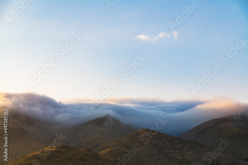 Beautiful mountains landscape, huge fluffy clouds descended to the mountain tops. Nature mountain wallpaper.