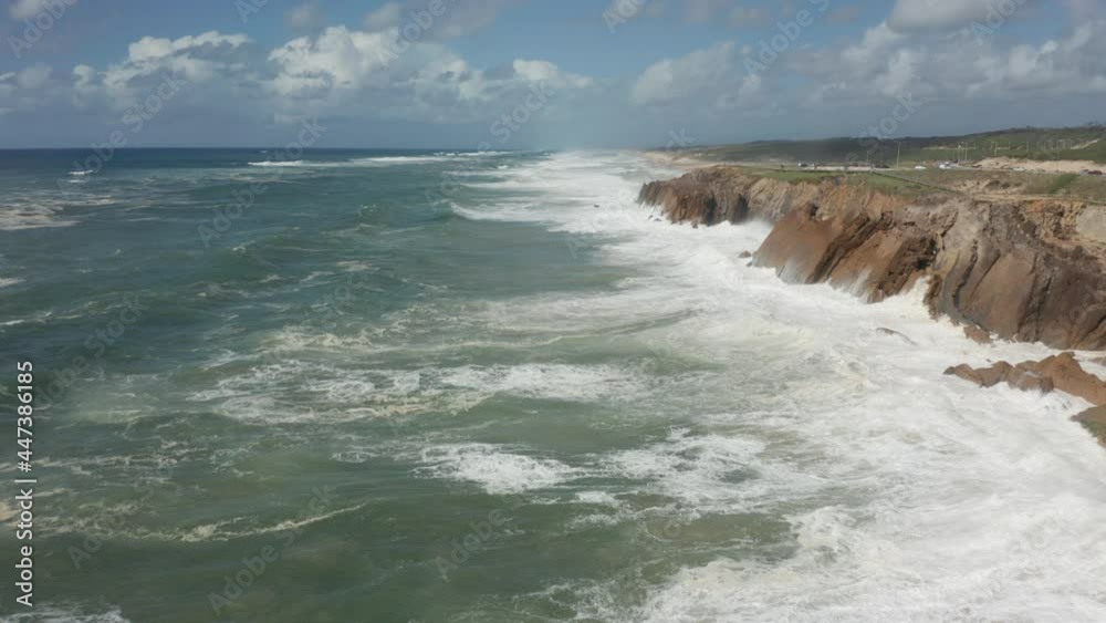 Flying low over heavy white waves on a restless sea