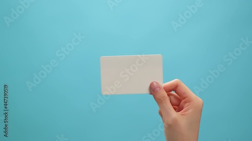 Hand holding mockup white cards and showing on the blue background.