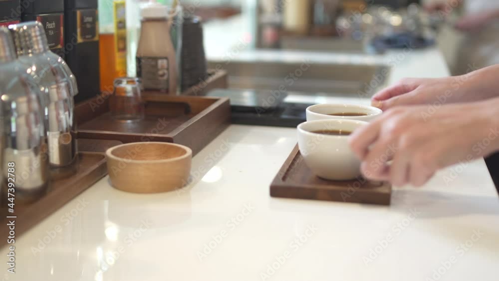 Asian woman coffee shop waitress barista serving hot coffee to customer on bar counter at cafe. Female restaurant cashier taking order from client. Small business owner and part time working concept Asian woman coffee shop waitress barista serving hot coffee to customer on bar counter at cafe. Female restaurant cashier taking order from client. Small business owner and part time working concept