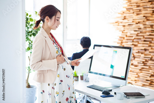 Foto オフィスで働く妊娠中の会社員女性