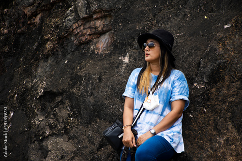 Asian travelers thai women travel visit and posing portrait on cliff mountain for take photo at Tham krasae cave in Sai Yok Waterfalls National Park at Tham krasae cave in Kanchanaburi, Thailand photo