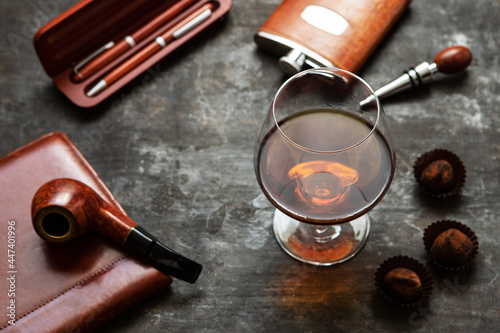 Glass of brandy or cognac and accessories on dark table