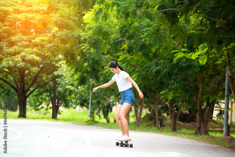 Attractive female teenager resting with a longboardskate . Sport activity lifestyle concept, Healthy and exercise.