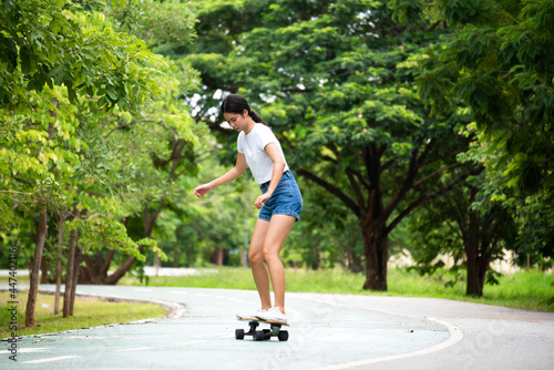 Attractive female teenager resting with a longboardskate . Sport activity lifestyle concept  Healthy and exercise.