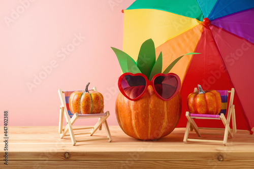 Halloween pumpkin creative decor as pineapple with sunglasses on wooden table