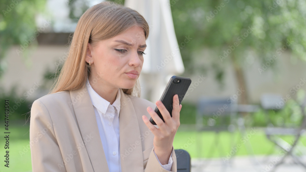 Outdoor Businesswoman Upset by Loss on Smartphone Outdoor Businesswoman Upset by Loss on Smartphone
