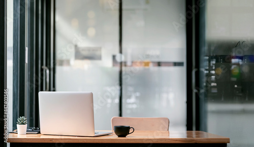 Wallpaper Mural Rear view of laptop computer and  coffee cup on wooden table in modern office room with copy space. Torontodigital.ca