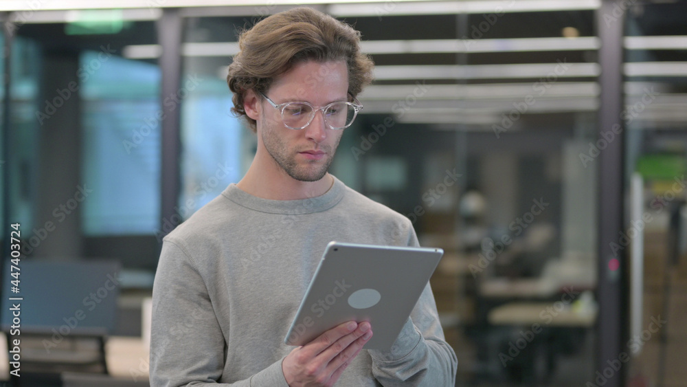Young Man using Digital Tablet, Browsing Internet Young Man using Digital Tablet, Browsing Internet