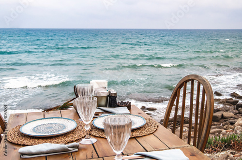 table and chairs on the beach. Cafe with wooden tables and chairs at seaside