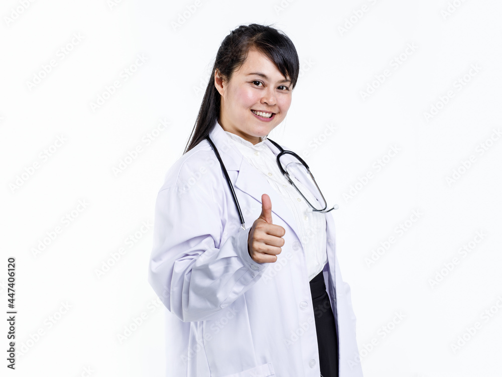 Cheerful young Asian female physician in medical uniform with stethoscope looking at camera and demonstrating thumb up gesture against white background Cheerful young Asian female physician in medical uniform with stethoscope looking at camera and demonstrating thumb up gesture against white background