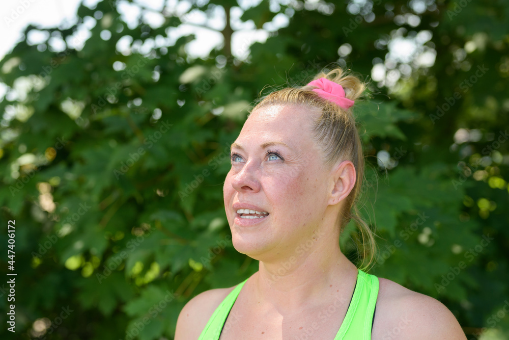 Attractive plump blond woman looking up at the sky Attractive plump blond woman looking up at the sky