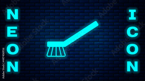Glowing neon Brush for cleaning icon isolated on brick wall background. Cleaning service concept. Vector