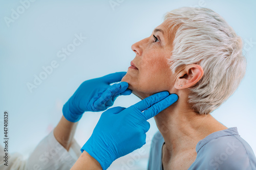 Endocrinologist Examining Senior Woman with Thyroid Gland Problems at a Clinic. photo