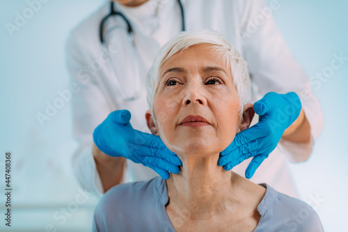 Thyroid Gland Control. Endocrinology Doctor Examining Senior Woman at Clinic. photo