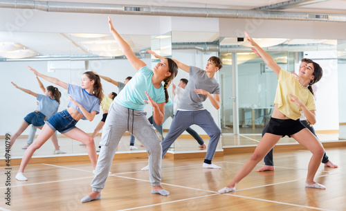 Fototapeta Naklejka Na Ścianę i Meble -  Positive teenage dancers doing dance workout during group class