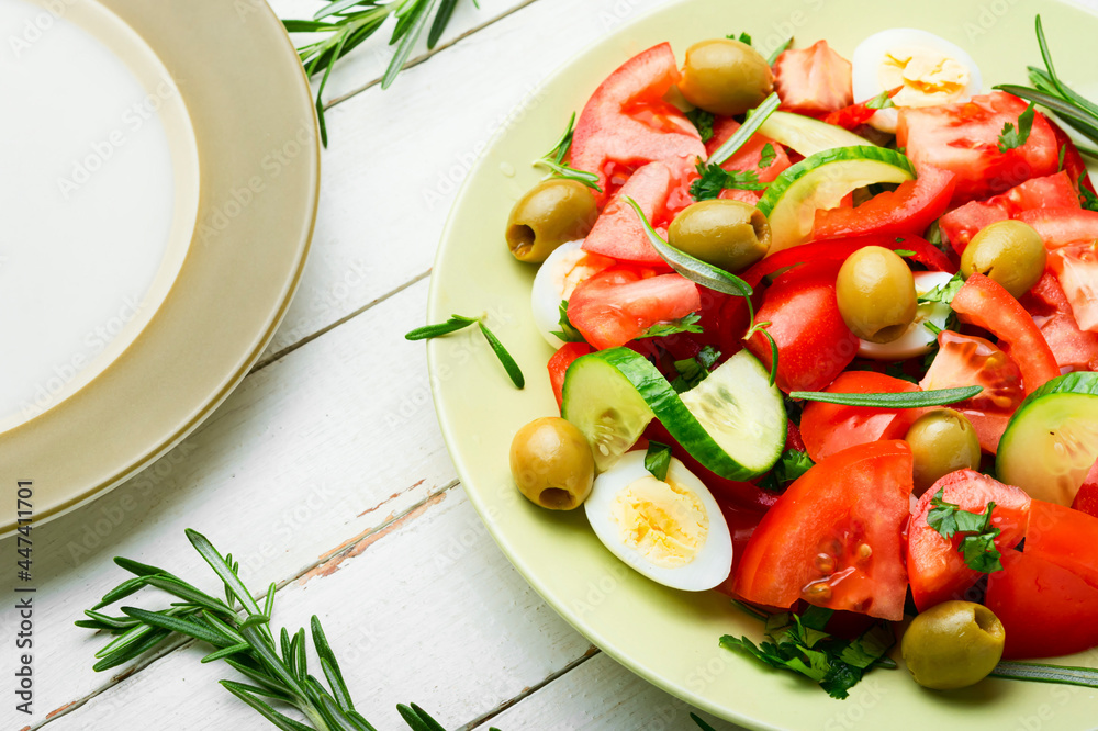 Salad with vegetables, olives, eggs and rosemary