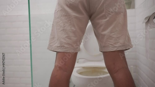 a man peeing standing up in the restroom shoot from behind