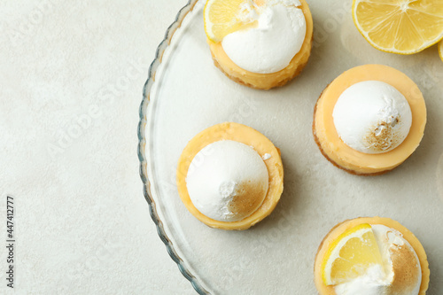 Tasty lemon cupcakes on tray on white textured table