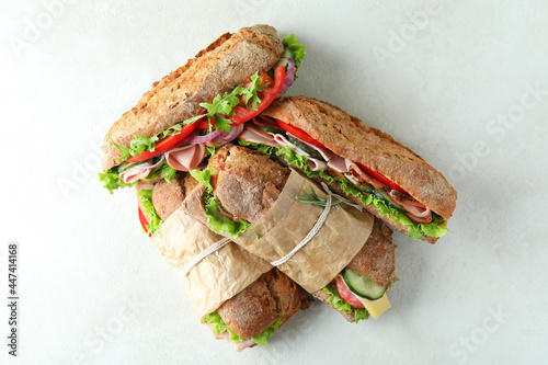 Tasty ciabatta sandwiches on white textured background