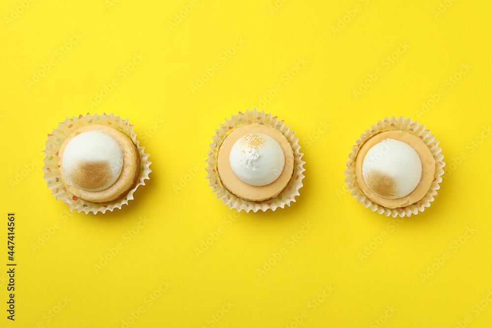 Lemon cupcakes on yellow background, top view Lemon cupcakes on yellow background, top view