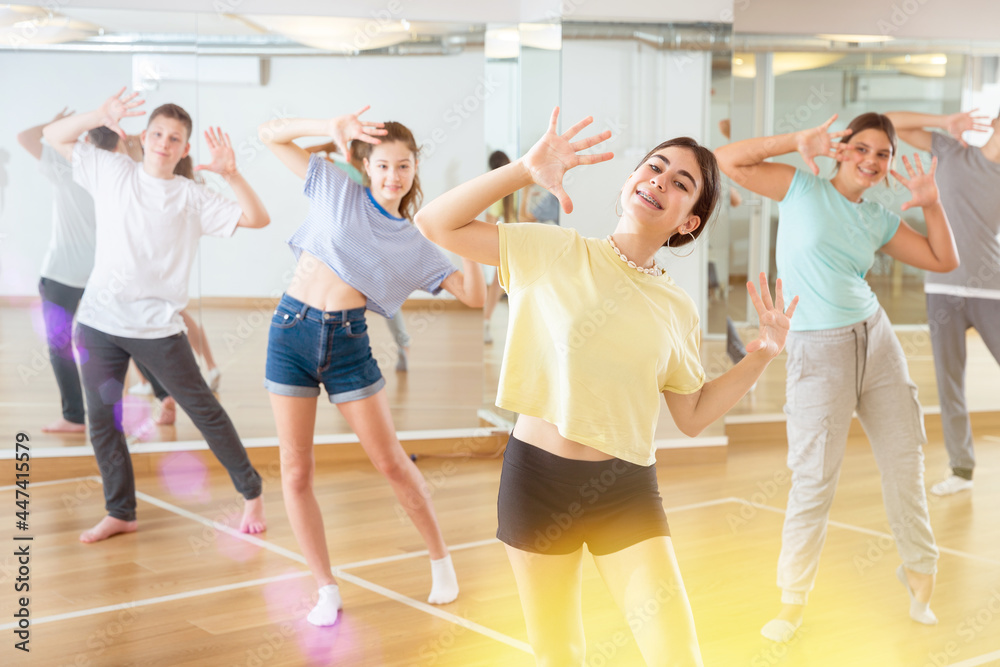 Positive teenagers are dancing hip hop in dance studio