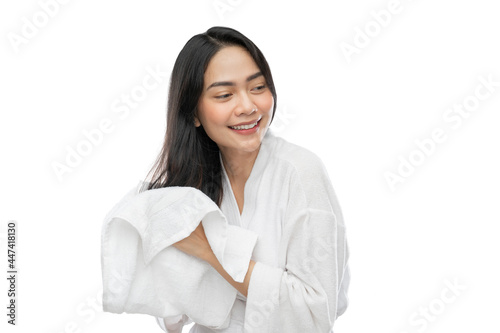 asian woman in towel drying her long hair with a towel after bathing on a gray background