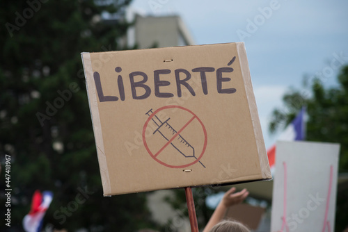  Portrait of people protesting in the street against the sanitary pass with banner and text in french : liberty, traduction in english : freedom photo