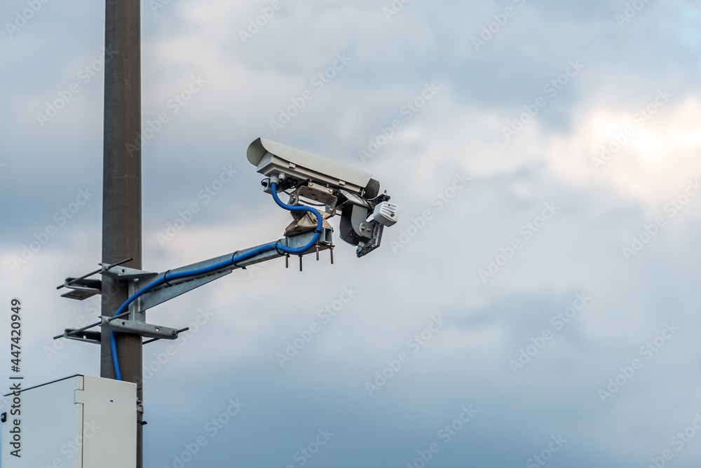 Street speed camera on the road against the background of the sky. Street speed camera on the road against the background of the sky.