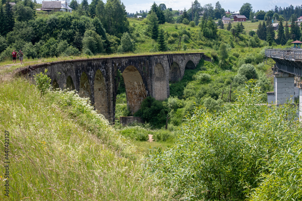 Old viaduct in Vorokhta, Carpathians. View from the bridge to the bend and the columns below surrounded by lush greenery