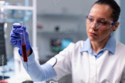 Chemist doctor analyzing blood test tube working at chemistry virus experiment in microbiology hospital laboratory. Scientist researcher researching illness infection discovering medical diagnostic