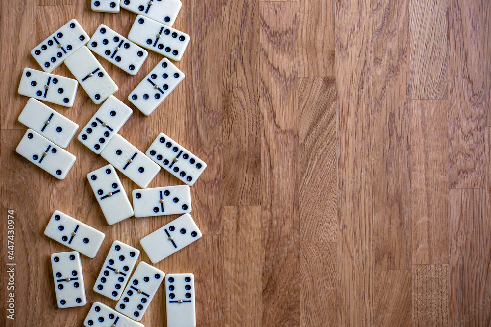 White dominoes on the wooden background, top view. Board game. Place for text