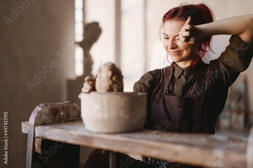 Young woman sculptor artist creating a bust sculpture