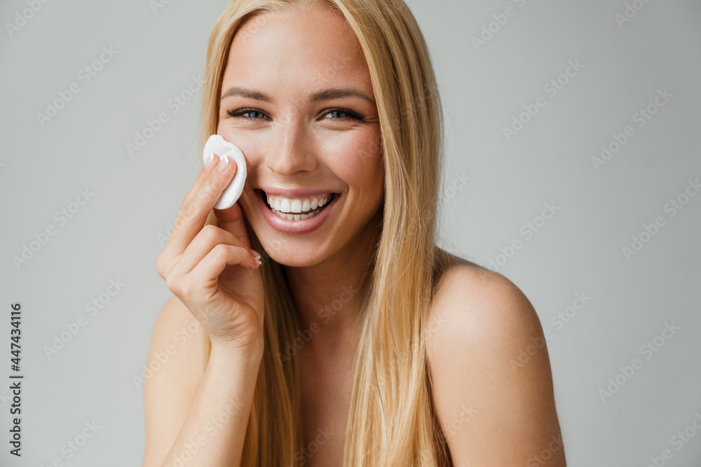 Half-naked blonde woman laughing while using cotton pad Half-naked blonde woman laughing while using cotton pad
