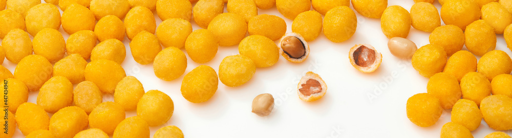 Yellow salty roasted peanuts with bacon flavor on white surface Yellow salty roasted peanuts with bacon flavor on white surface