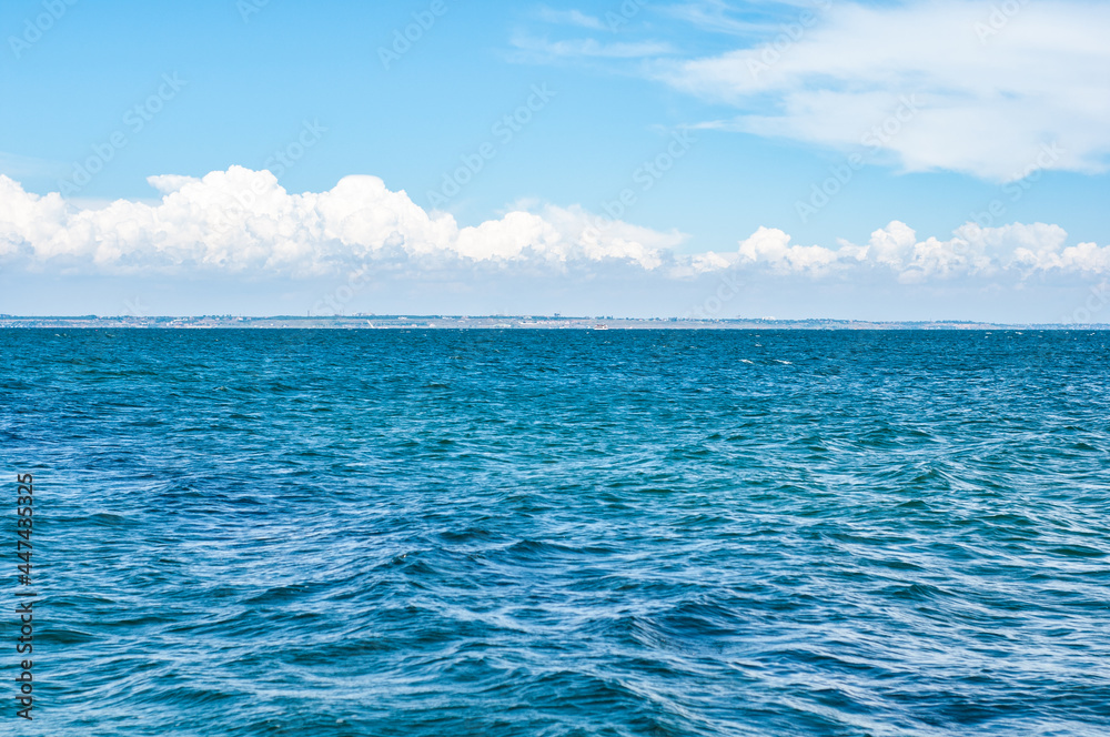 Obraz premium Empty landscape with blue sea water under dramatic cloudy sky with clouds.