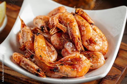 Roasted garlic shrimp appetizer with beer on wooden background