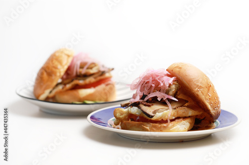 Homemade chicken burger with cheese and french fries on a plate isolated on white background