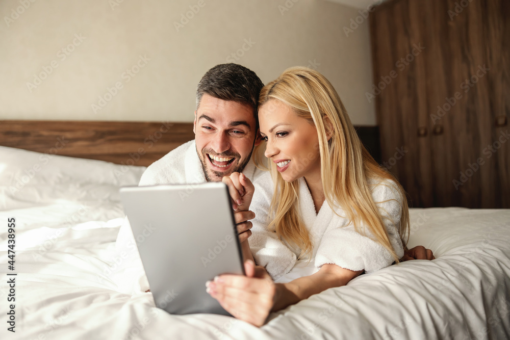 Weekends for relaxation, online spa reservations from a hotel room. The handsome guy is having his lover in his lap and gently hugging her Online payment Online dinner and spa reservation Credit card Weekends for relaxation, online spa reservations from a hotel room. The handsome guy is having his lover in his lap and gently hugging her Online payment Online dinner and spa reservation Credit card