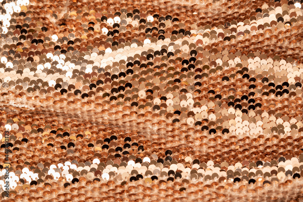 Fototapeta premium Golden shiny background, fabric background with sparkle. Sequins on the textile with folds. Close up