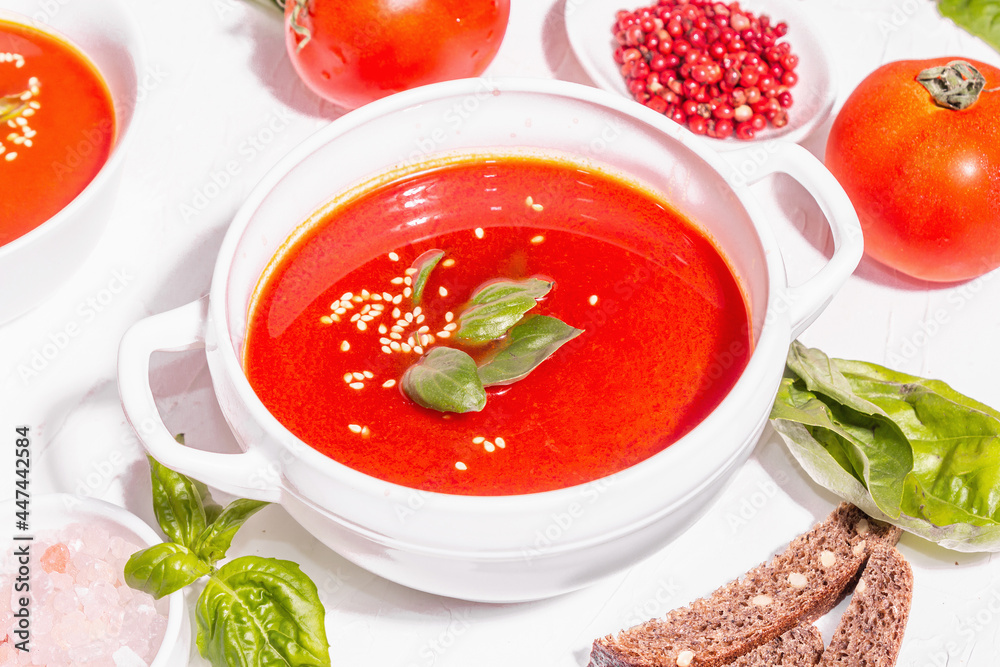 Bowls with homemade tomato soup. Ripe vegetables, fresh basil leaves, breadsticks, aromatic spices Bowls with homemade tomato soup. Ripe vegetables, fresh basil leaves, breadsticks, aromatic spices