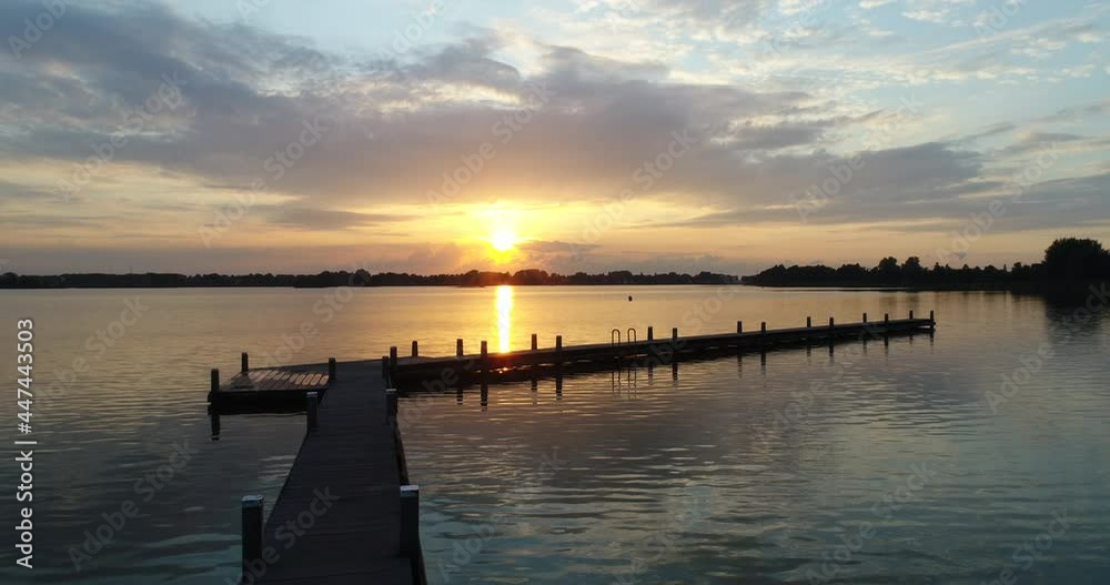 Wooden Jetty On Lake During Beautiful Sunset In Reeuwijk, Netherlands. - aerial drone, wide Wooden Jetty On Lake During Beautiful Sunset In Reeuwijk, Netherlands. - aerial drone, wide