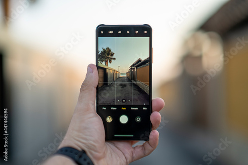 Smartphone con la cámara enseñando calle de pueblo costero