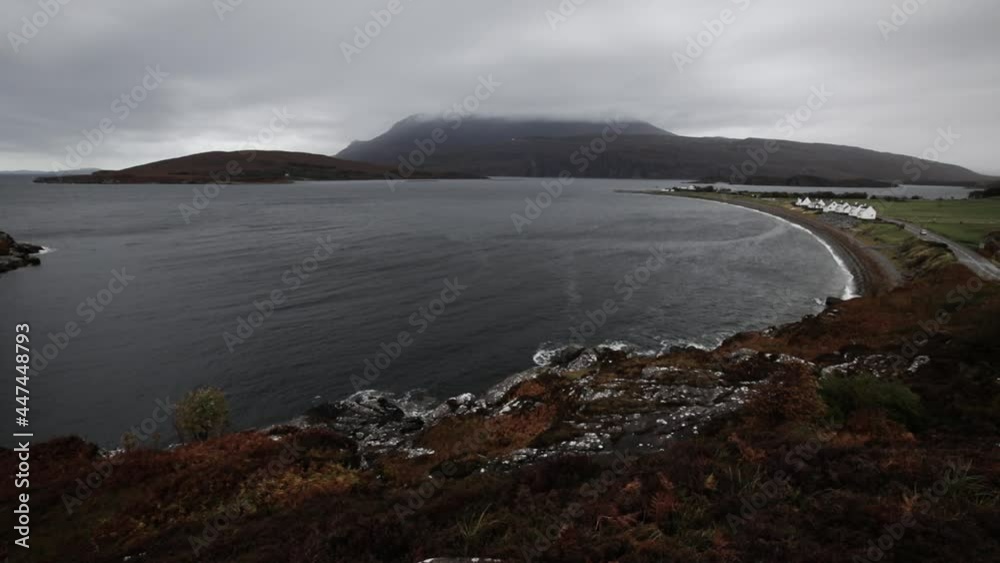 A calm, cozy oceanside village on the coast of the Highlands of Scotland under a overcast cloudy sky. A calm, cozy oceanside village on the coast of the Highlands of Scotland under a overcast cloudy sky.