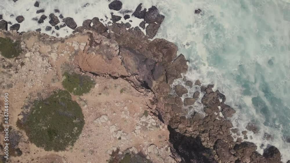 Aerial top down flight over high rock cliffs and crashing waves of Atlantic Ocean in Portugal Aerial top down flight over high rock cliffs and crashing waves of Atlantic Ocean in Portugal